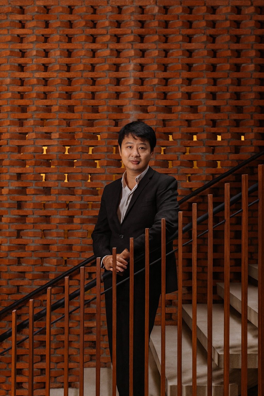 Dr. Marcus Yu Bin Pai em uma escadaria moderna