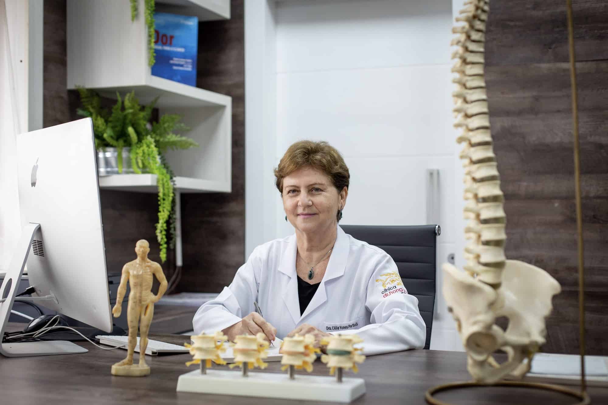 Dra. Célia Yunes Portiolli à mesa do consultório.