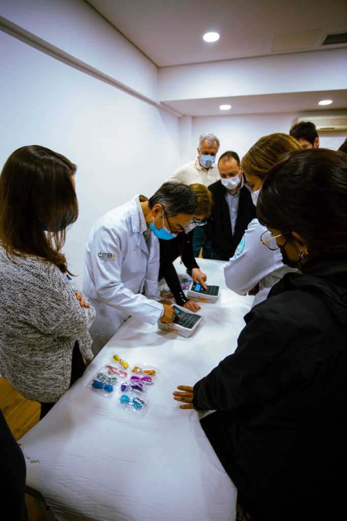 A Acupuntura na oncologia 8 Instrutor demonstrando aparelho de eletroacupuntura para grupo de alunos ao redor da mesa
