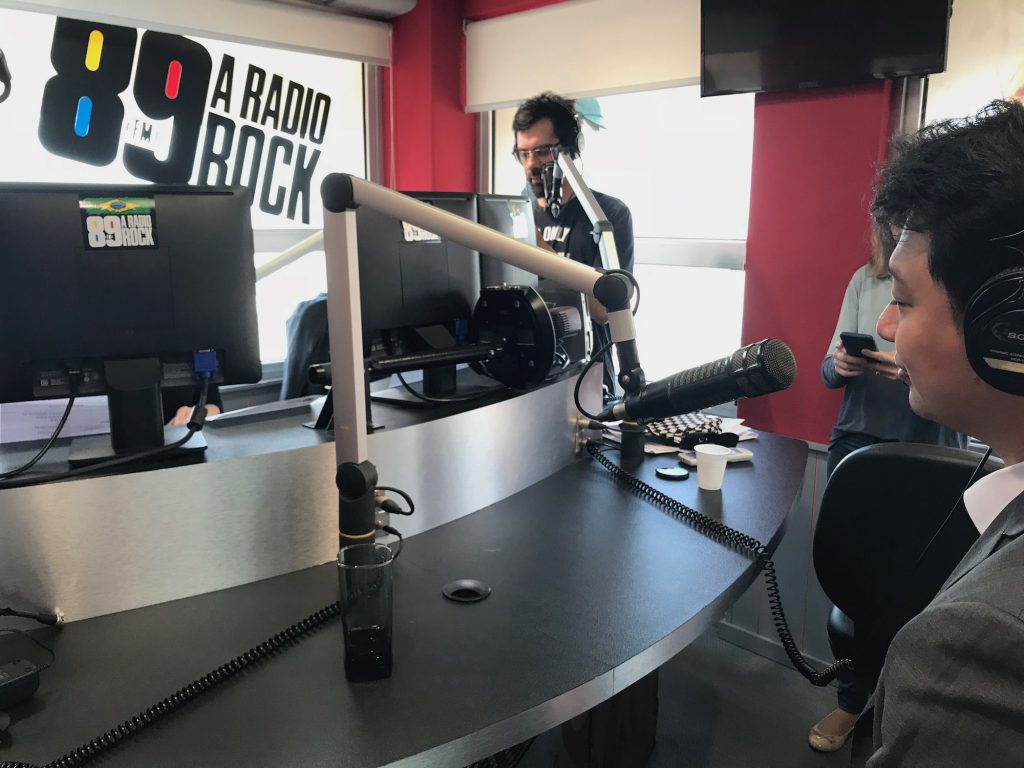 Dr. Marcus Yu Bin Pai sendo entrevistado ao microfone no estúdio da rádio 89 Rock