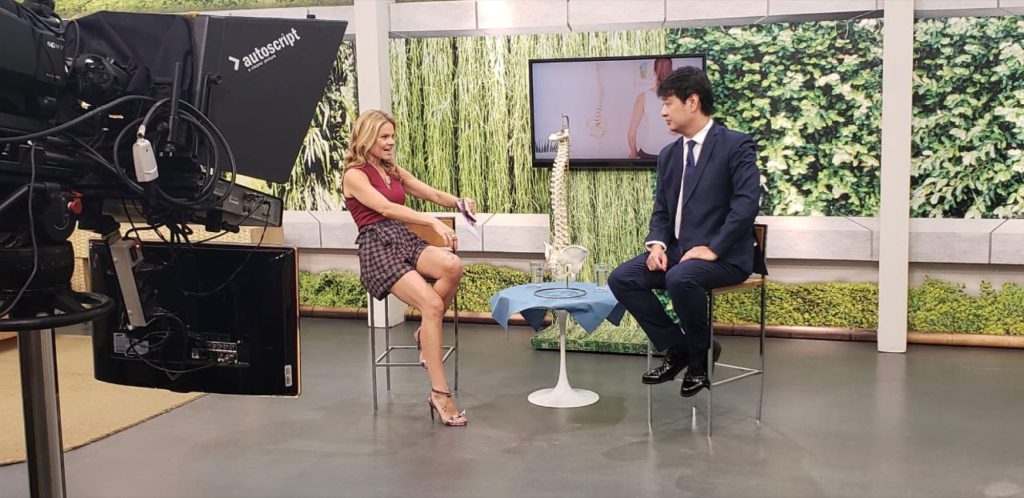 Dor e fraqueza: o que está acontecendo? 7 Dr. Marcus Yu Bin Pai entrevistado em estudio de televisao sobre dor na coluna com modelo anatômico