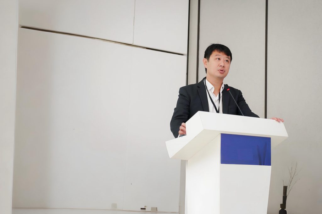 Dr. Marcus Yu Bin Pai discursando ao microfone no pulpito durante palestra no congresso CBDor