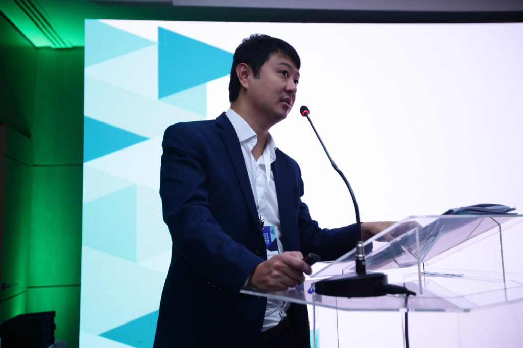 Cymbalta (Duloxetina) para dor crônica 6 Dr. Marcus Yu Bin Pai palestrando ao microfone em tribuna durante congresso médico