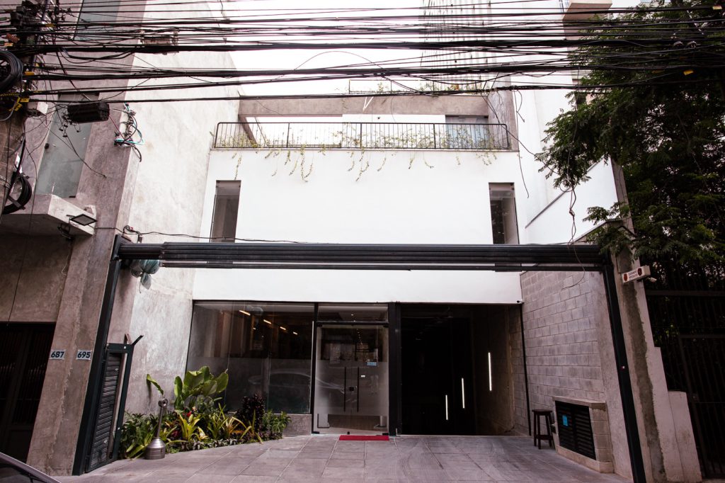 Fachada completa do prédio da clinica com três pavimentos e terraco ajardinado