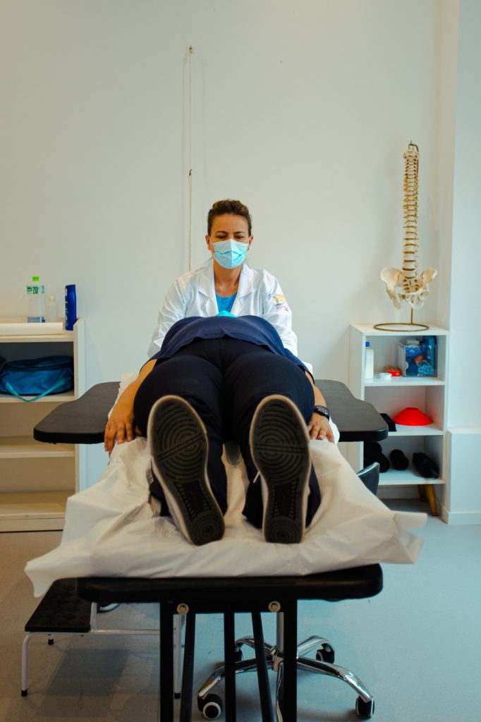 O que é Modic tipo I, Modic tipo II ou Modic tipo III? 5 Fisioterapeuta tratando os membros inferiores de paciente deitado na maca de fisioterapia