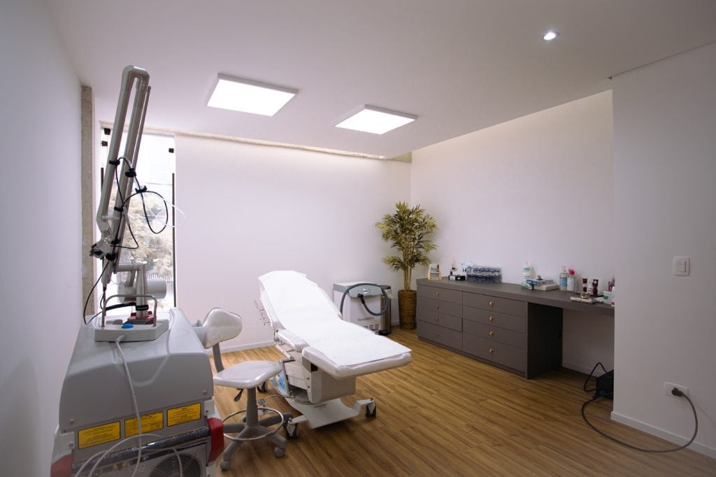 Sala de procedimentos a laser com equipamento, maca e bancada de insumos