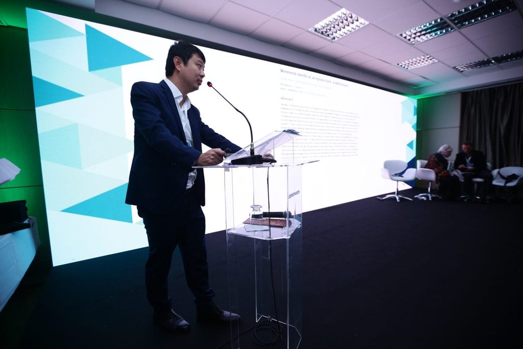 Dr. Marcus Yu Bin Pai ministrando aula médica sobre dor